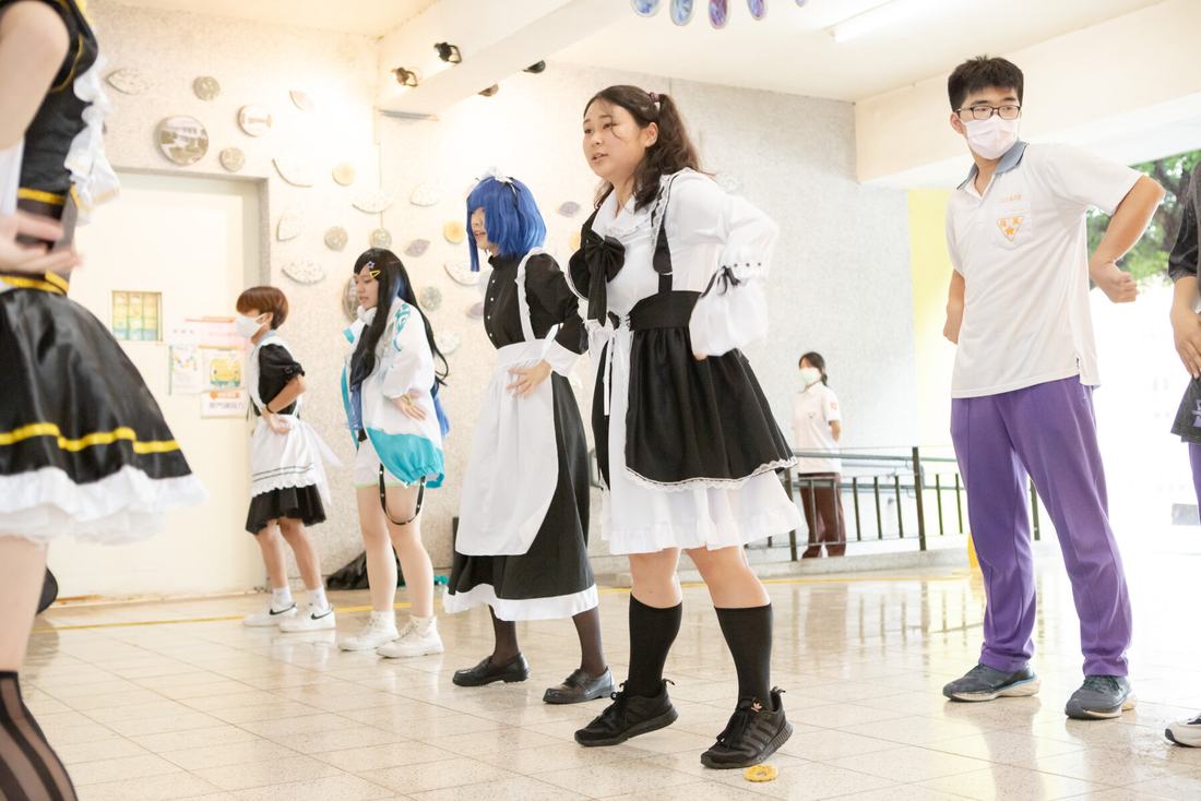 多名身著主題服裝的學生在室內場地排成一列表演。