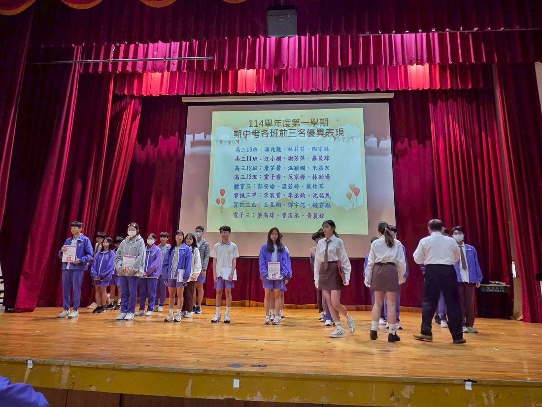 全體受獎學生在舞台上列隊，投影幕顯示得獎名單。