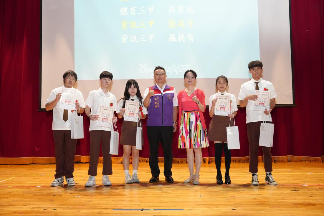 數名學生在舞台上與師長合影，人數較少。
