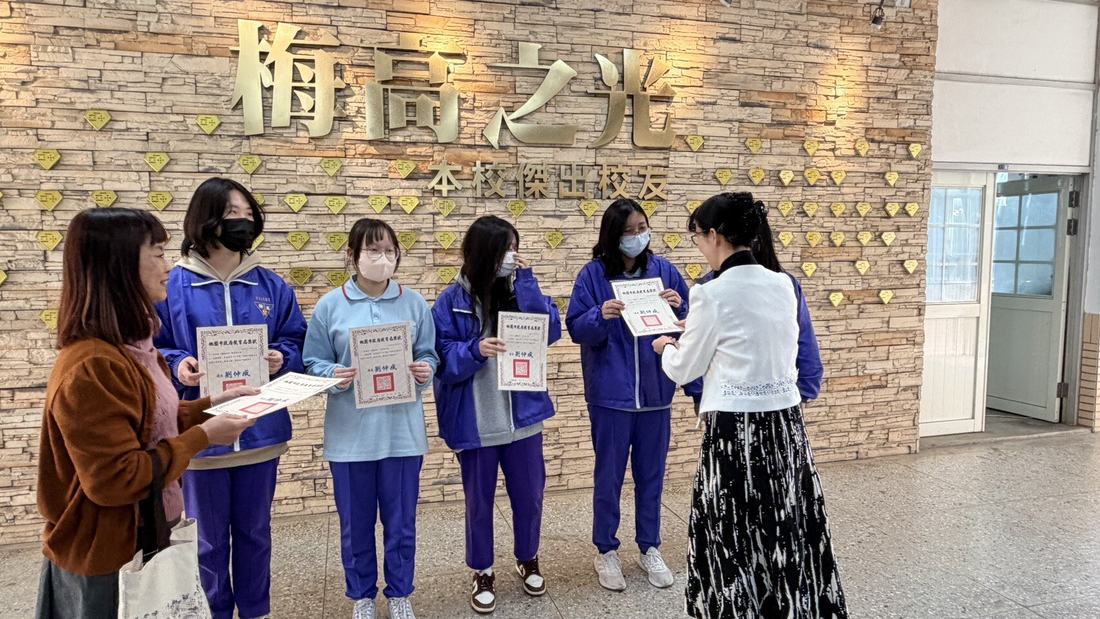 教師持名單在梅高之光牆前為學生頒獎。