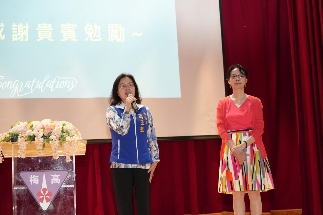 兩位主持人在講台旁主持典禮進行。