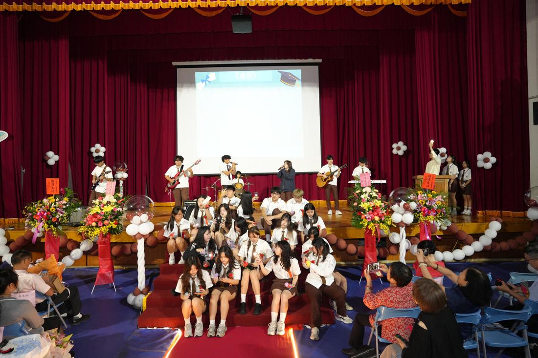 舞台典禮進行中，台上人員發言，台下座無虛席。