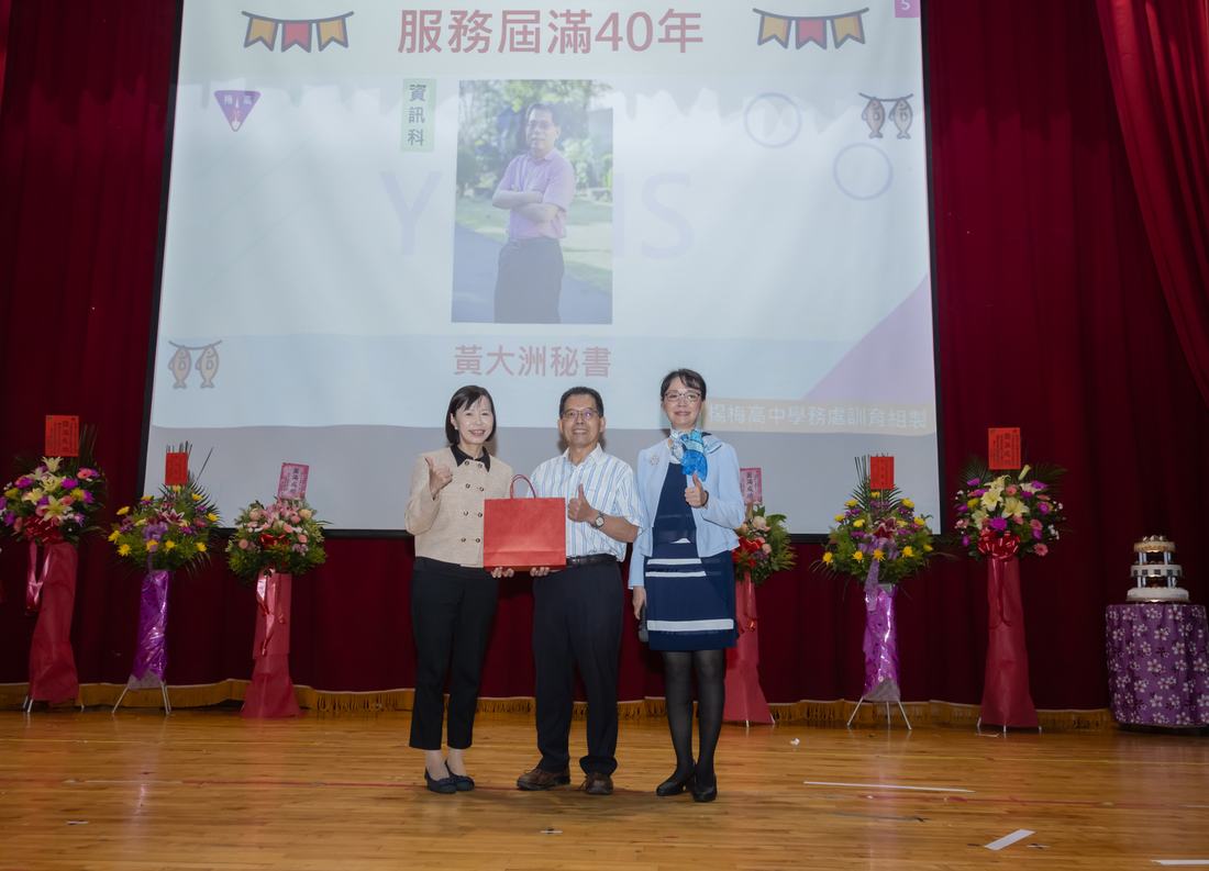 舞台上教師接受頒獎，投影幕顯示服務屆滿四十年字樣。
