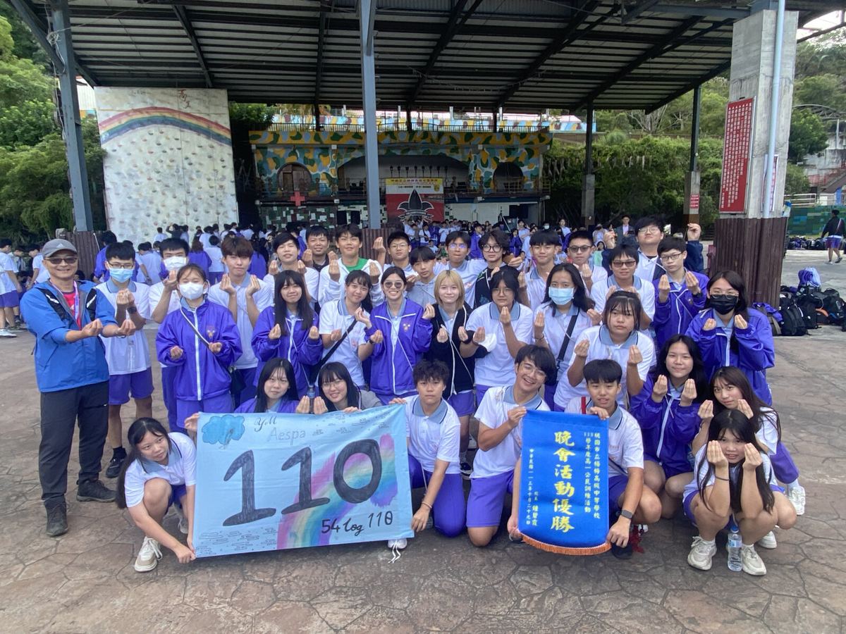 集會亭前的大合照，同學手持寫有「110」的班旗。