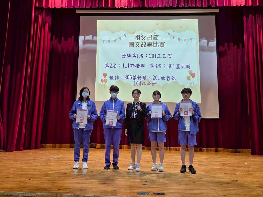 禮堂舞台上受獎學生手持獎狀合影，投影幕顯示圖文寫作比賽得獎名單。