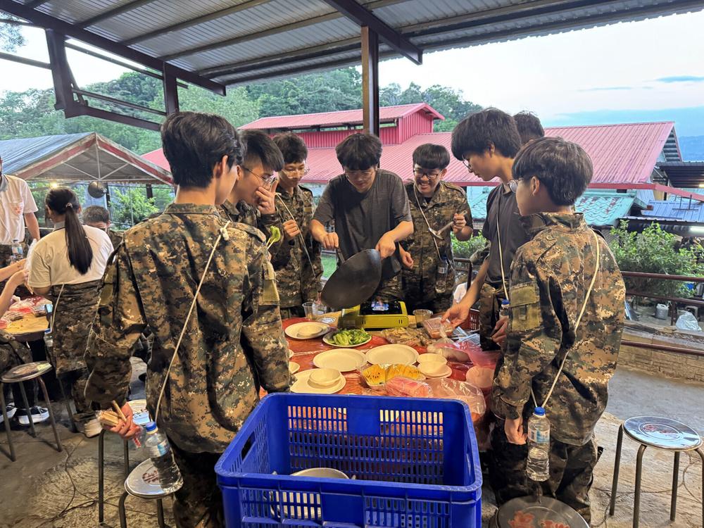 學員圍在長桌旁準備烤肉食材。